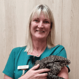 Image shows Practice manager and RVN Sonia Green smiling at Chorley vets holding a reptile