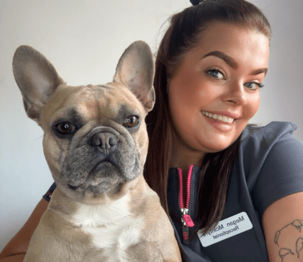 Megan McIntyre the Receptionist at Chorley Vets holding a dog